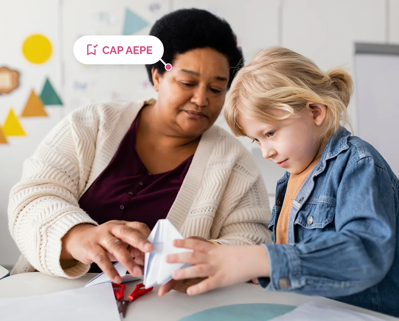 Professionnelle de la petite enfance accompagnant un enfant dans une activité de découpage